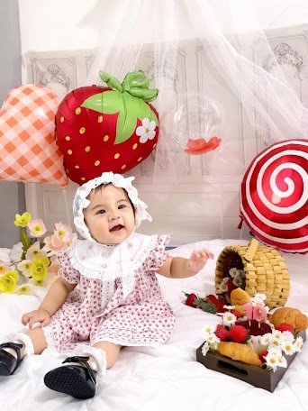 Ciara smiling in a strawberry-themed setup